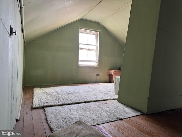 additional living space with lofted ceiling and hardwood / wood-style floors