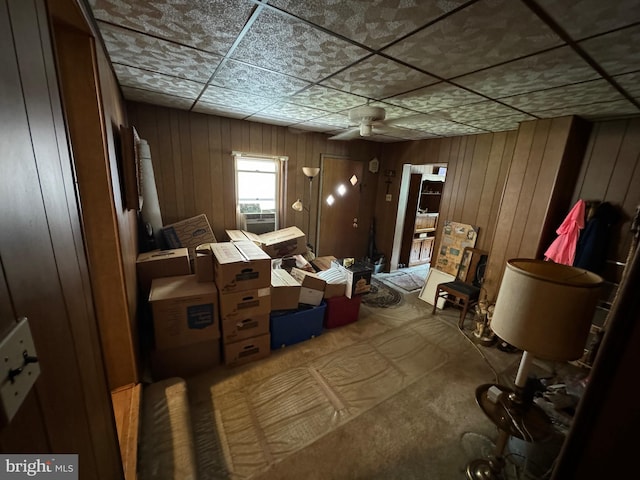 misc room featuring a paneled ceiling and wooden walls