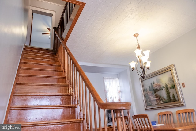 staircase with an inviting chandelier