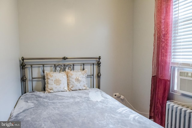 bedroom featuring multiple windows and radiator