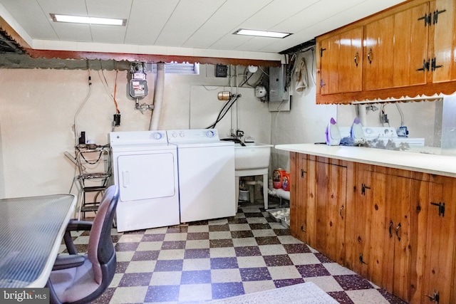 laundry area featuring sink, cabinets, dark tile patterned floors, and independent washer and dryer