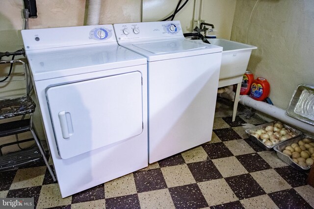 washroom featuring washing machine and clothes dryer, sink, and tile patterned flooring