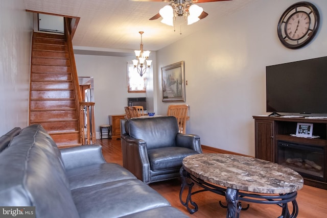 living room with wood-type flooring and ceiling fan with notable chandelier