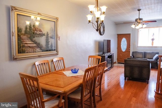 dining space featuring ceiling fan with notable chandelier and wood-type flooring