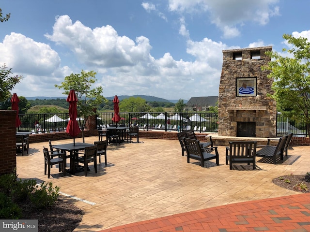 view of patio featuring an outdoor stone fireplace