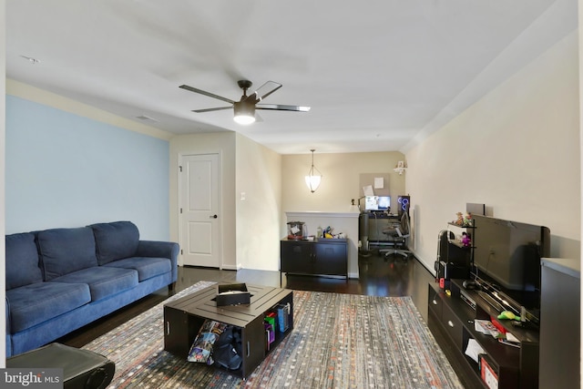 living room with ceiling fan and dark wood-type flooring