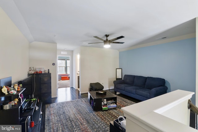 living room featuring ceiling fan and dark hardwood / wood-style floors