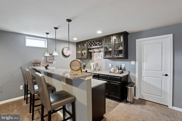 bar featuring pendant lighting, light stone countertops, light colored carpet, and dark brown cabinets