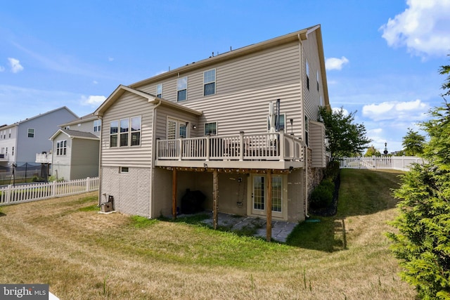 rear view of property with a deck and a yard