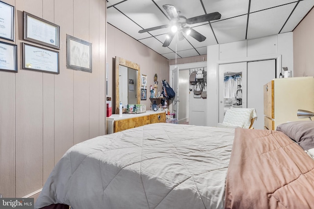 bedroom with wooden walls and ceiling fan