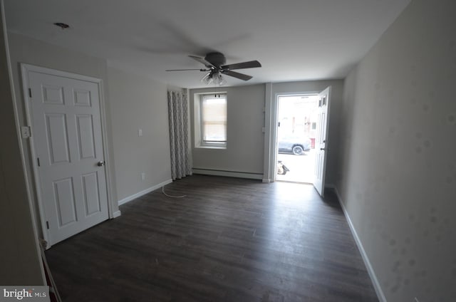 spare room featuring a baseboard radiator, ceiling fan, and hardwood / wood-style floors