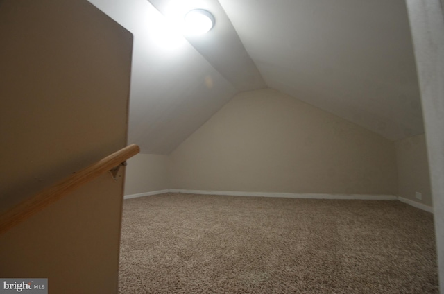 bonus room with vaulted ceiling and carpet flooring