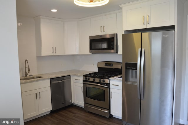 kitchen with white cabinetry, stainless steel appliances, sink, and dark wood-type flooring