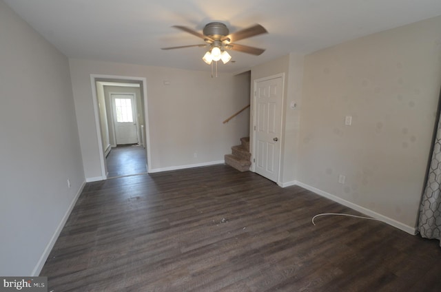 empty room with dark wood-type flooring and ceiling fan