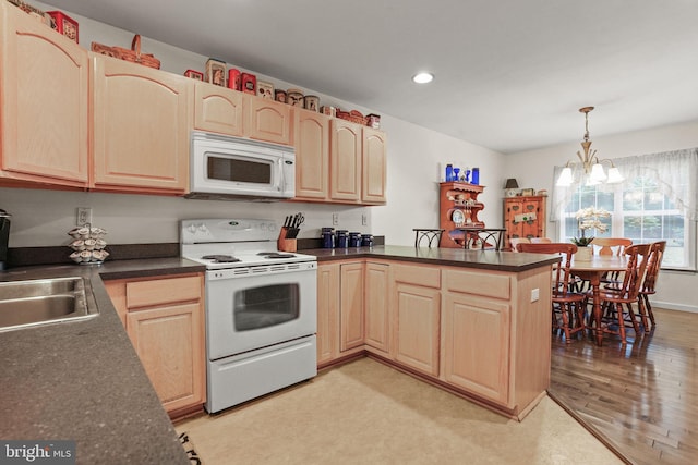 kitchen featuring decorative light fixtures, a notable chandelier, kitchen peninsula, white appliances, and light hardwood / wood-style flooring