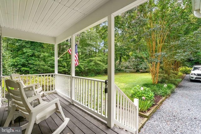 wooden deck with a yard and covered porch