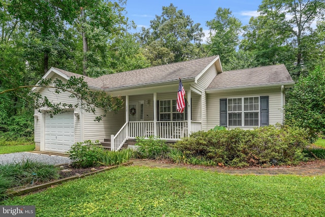 view of front of home featuring a garage, a front yard, and covered porch