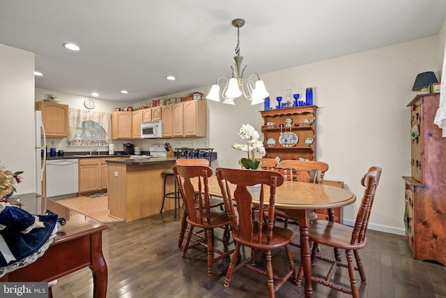 dining space with hardwood / wood-style floors and a notable chandelier