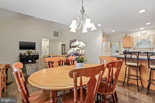 dining space with an inviting chandelier, wood-type flooring, and lofted ceiling