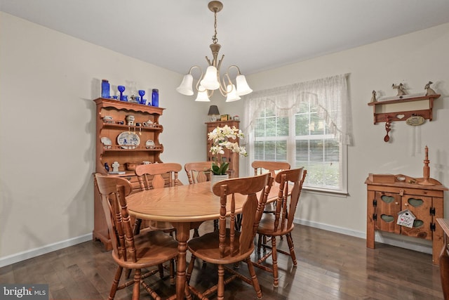 dining space with dark hardwood / wood-style floors and a chandelier