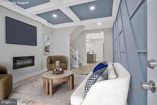 living room featuring coffered ceiling, light wood-type flooring, and beam ceiling