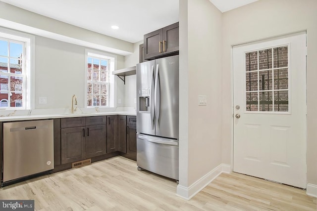 kitchen featuring dark brown cabinetry, a sink, visible vents, appliances with stainless steel finishes, and open shelves