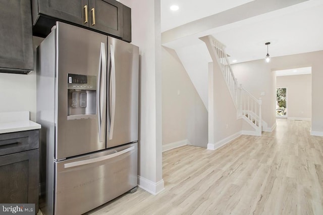 kitchen featuring light wood-style flooring, recessed lighting, baseboards, light countertops, and stainless steel fridge with ice dispenser