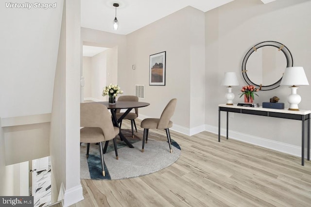 dining area featuring light wood-type flooring, visible vents, and baseboards