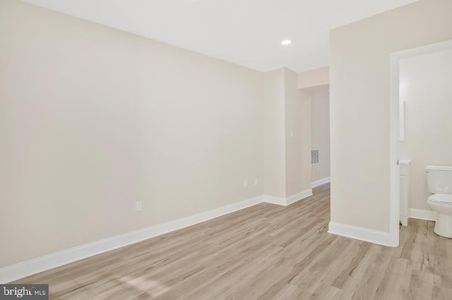 empty room featuring light wood finished floors, recessed lighting, and baseboards