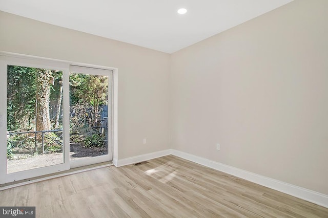 spare room with visible vents, light wood-style floors, a wealth of natural light, and baseboards