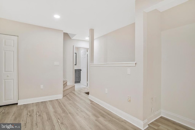 spare room featuring baseboards, stairway, wood finished floors, and recessed lighting