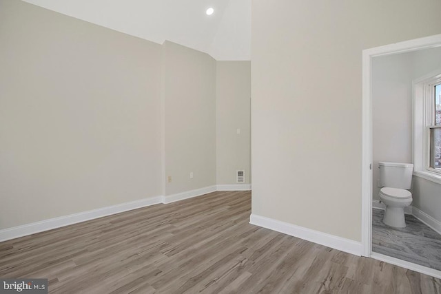 interior space featuring recessed lighting, visible vents, vaulted ceiling, light wood-type flooring, and baseboards