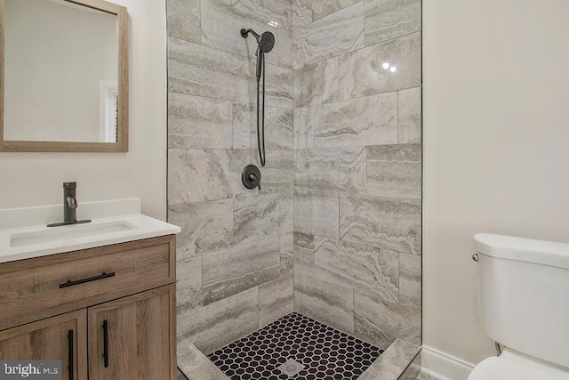 bathroom featuring tiled shower, vanity, and toilet