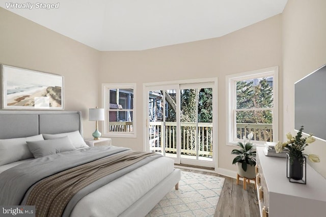 bedroom featuring baseboards, access to outside, and light wood-style floors