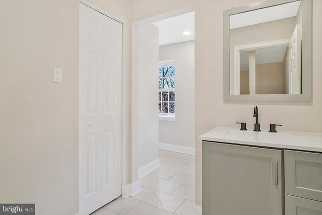 bathroom featuring marble finish floor, vanity, and baseboards