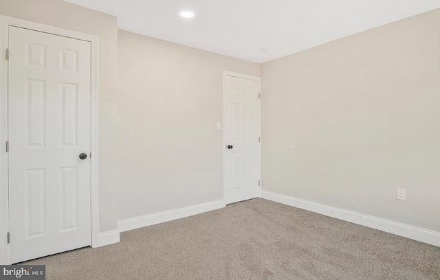 carpeted spare room featuring recessed lighting and baseboards