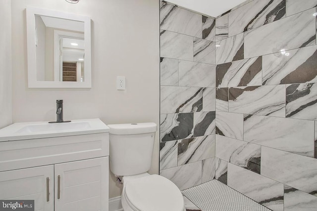 bathroom featuring tiled shower, vanity, and toilet