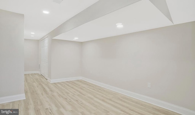 finished below grade area with light wood-style flooring, baseboards, and recessed lighting