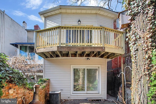 rear view of property featuring a deck and central AC