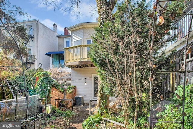 rear view of house featuring a balcony and central AC