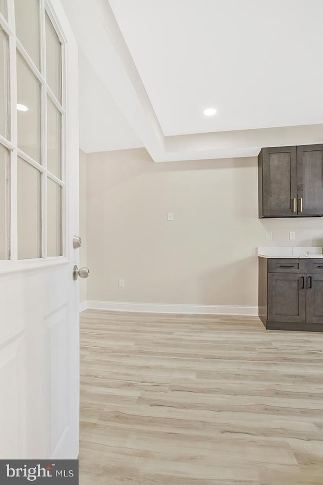 interior space featuring light wood-type flooring, baseboards, and recessed lighting