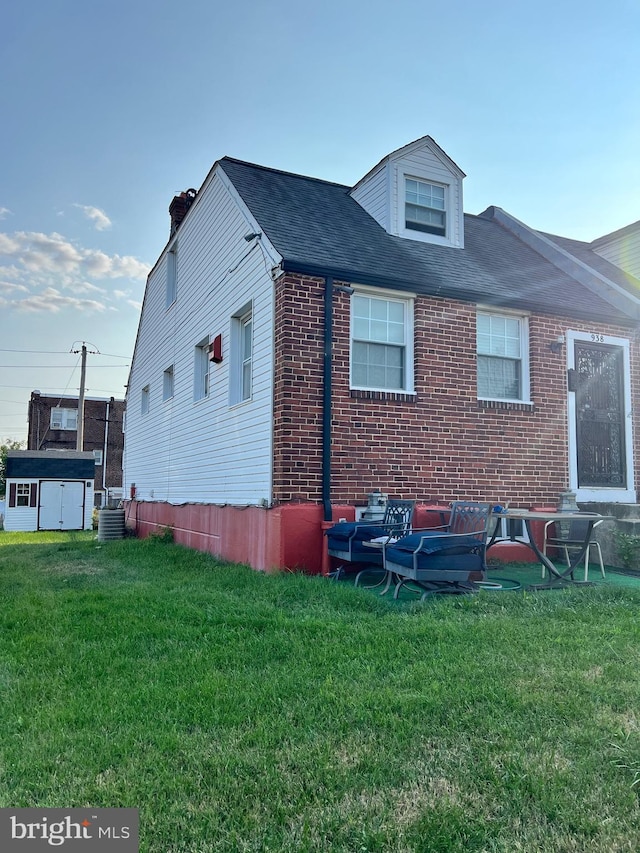 view of side of property featuring central AC unit and a lawn