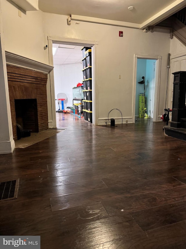 unfurnished living room featuring beamed ceiling and hardwood / wood-style floors