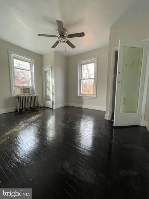 spare room with plenty of natural light, radiator, and ceiling fan