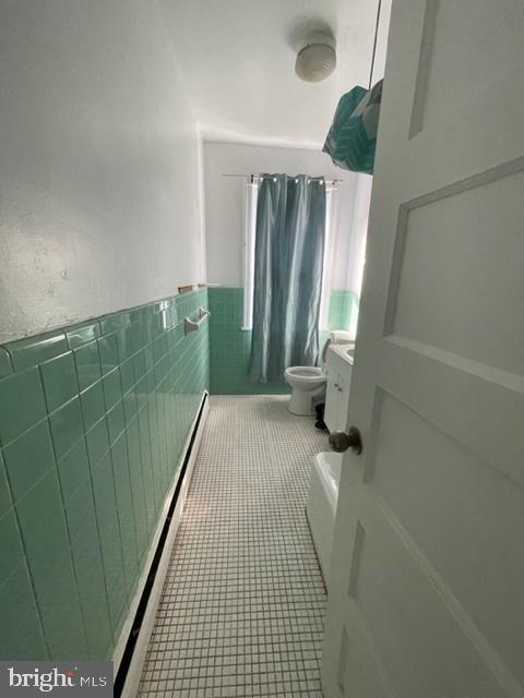 bathroom with vanity, toilet, tile patterned flooring, and tile walls