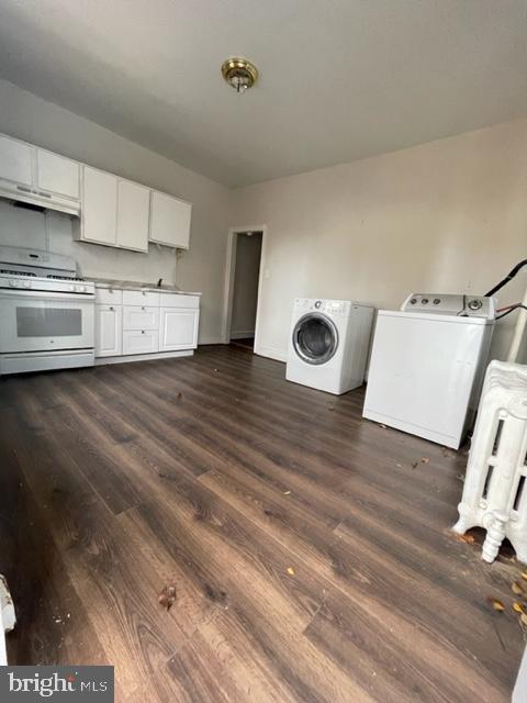 kitchen with white cabinetry, dark hardwood / wood-style flooring, washing machine and dryer, and gas range gas stove