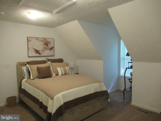 carpeted bedroom featuring a textured ceiling and vaulted ceiling