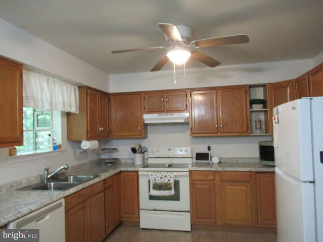 kitchen with white appliances, ceiling fan, light stone counters, and sink