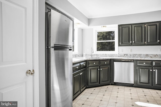 kitchen with crown molding, appliances with stainless steel finishes, sink, and light stone counters