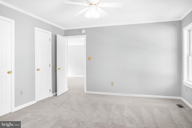 unfurnished bedroom featuring crown molding, light colored carpet, and ceiling fan